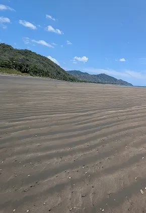 Playa desierta con cerros boscosos en la costa de Azuero