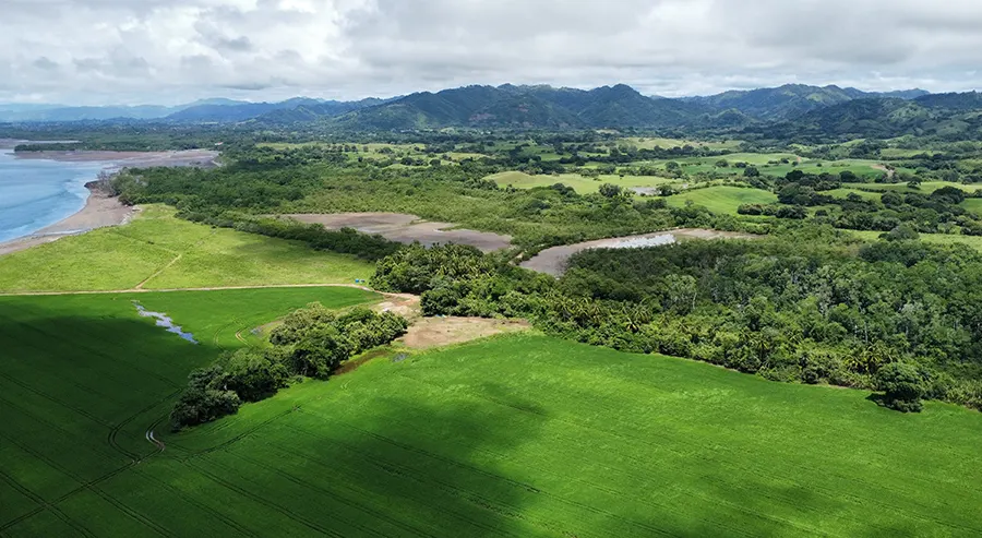 Terreno verde y ondulado de Vista Verde cerca de Playa Venao, con la costa y las montañas al fondo