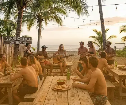 Friends playing music and sharing a meal at a community gathering in Playa Venao
