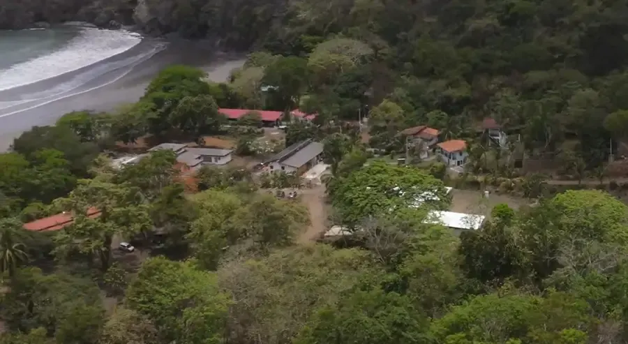 Aerial view of Playa Venao village, rooftops and forest near the beach